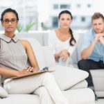 Marriage Counsellor with unhappy couple in therapists office